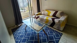 A living room with a sofa, a glass coffee table, and a patterned rug. - Santa Lucía, Downtown Central Santiago (Santiago)