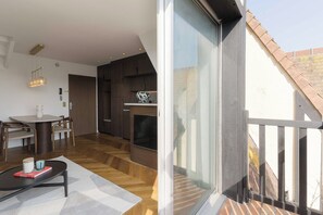 Ein modernes Interieur mit Essbereich, Kamin und einer großen Glastür zum Balkon.