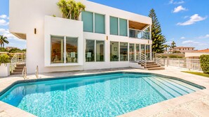 A modern two-story house with a swimming pool, large windows, and a staircase leading to the upper floor. - Villa Riviera Luxe, Coastal 4BR Retreat in Miami (Miami)