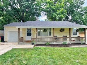 Ein eingeschossiges Haus mit Veranda, Garage und kleinem Vorgarten.