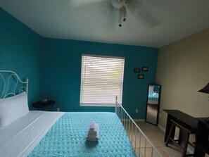 A room with a bed, a window with blinds, a desk, and a mirror. - 3-bedroom pool house in SW Cape Coral - pet friendly with fenced backyard (Cape Coral)