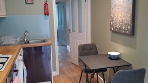 Una cocina moderna con encimera de madera, un lavamanos y una zona de comedor con mesa y sillas.