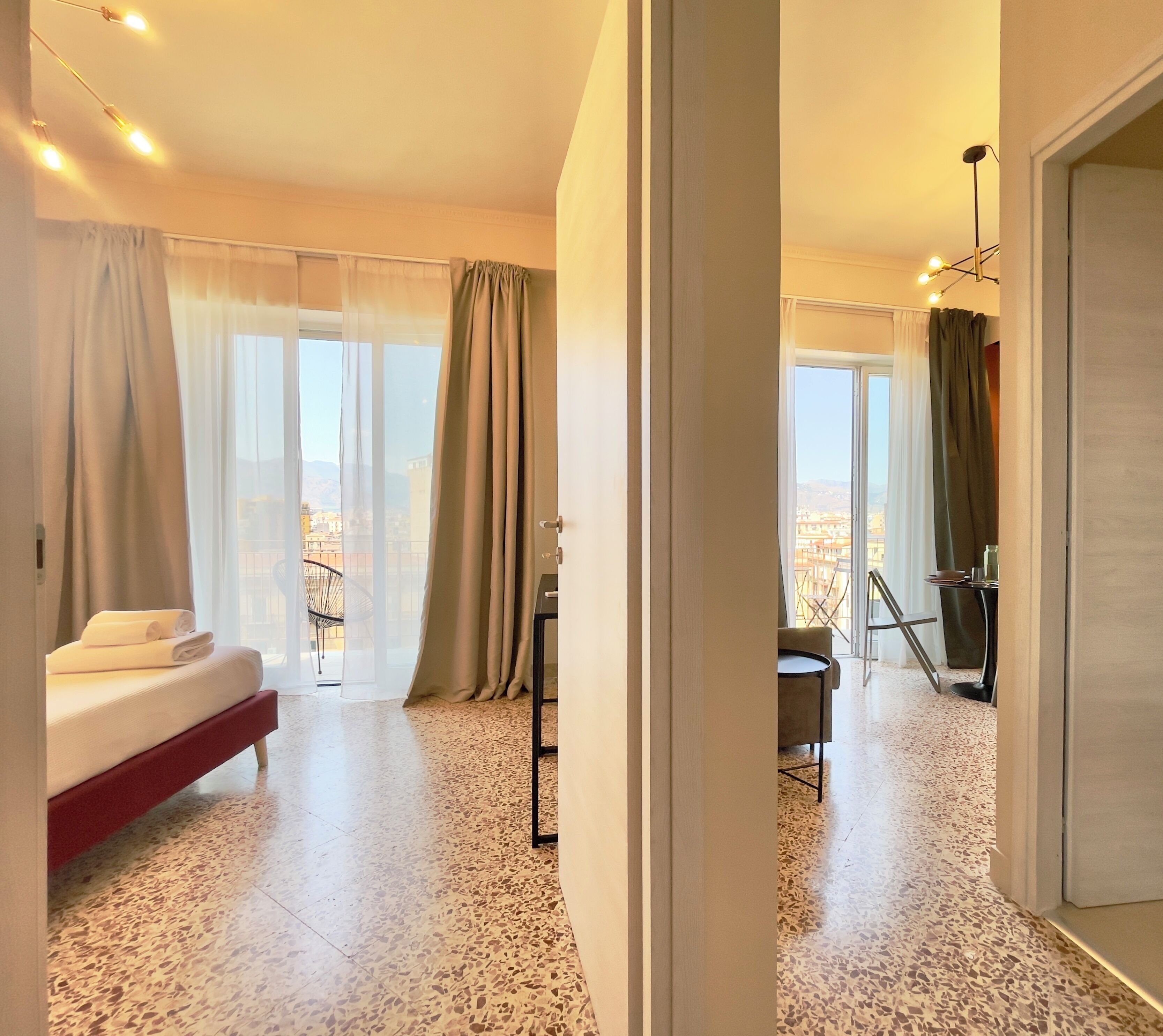 Une chambre d’hôtel avec un lit, une table à manger et une vue sur la ville.