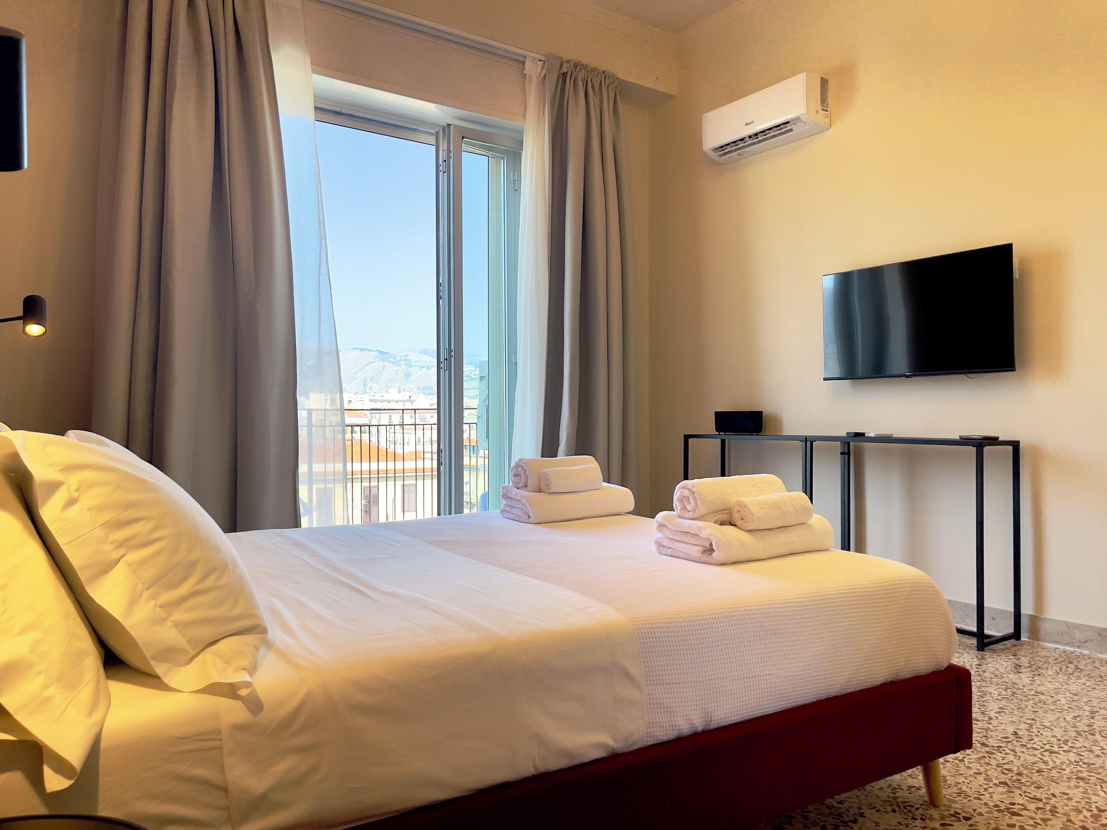Une chambre d’hôtel avec un lit, une télévision, une table et une vue sur l’extérieur.