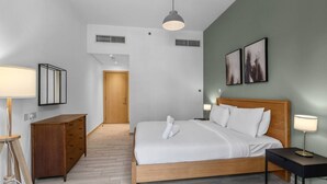 Ein modernes Hotelzimmer mit einem hölzernen Bett, einem Schreibtisch, einem Stuhl, einer Lampe und Bildern an der Wand.