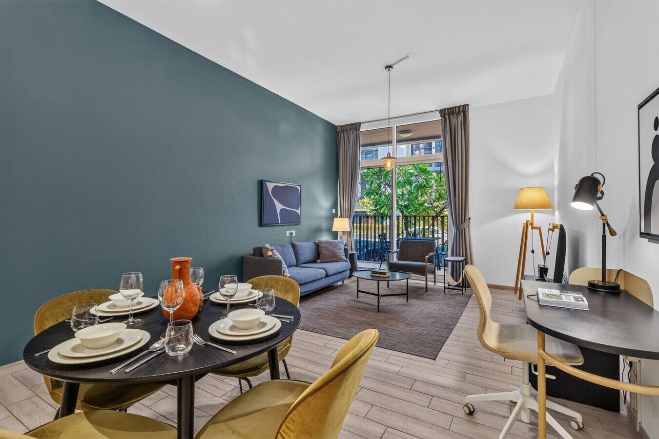 Una sala moderna con comedor, sofá y vistas al exterior.