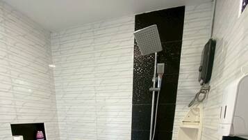 Une salle de bain moderne équipée d’une douche, de toilettes et d’un lavabo.