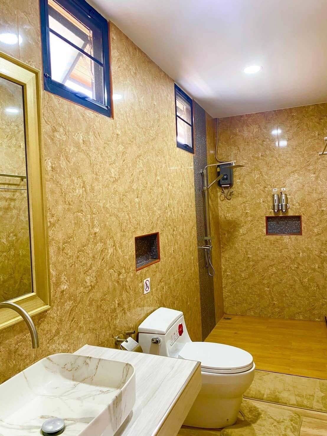 Ein Badezimmer mit Marmorwaschbecken, Toilette und Dusche.