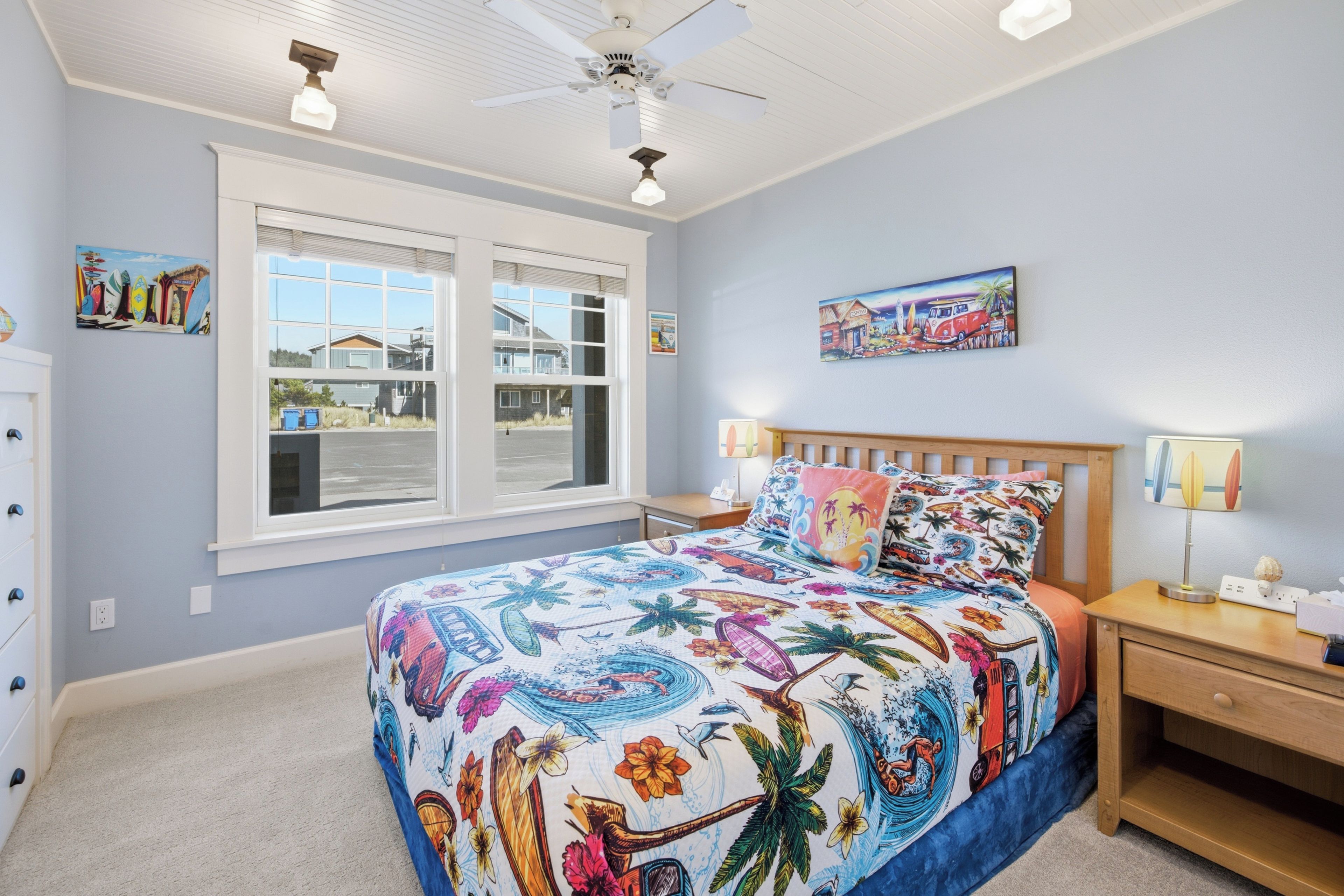 A bedroom with a bed, nightstands, a ceiling fan, and a window with blinds.