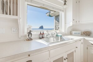 Eine Küche mit Blick auf den Strand, einem Spülbecken und einer Brotkiste.