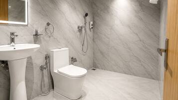 Une salle de bain moderne équipée de toilettes, d’un lavabo et d’une douche.