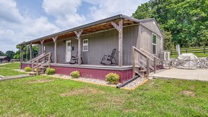 A single-story building with a porch, a door, and a small window. - Fire Pit, Grill! Mammoth Cave Cabin Near Boat Ramp (Mammoth Cave)