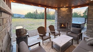 An outdoor patio with stone walls, a fire pit, and a hot tub. - Granby Mtn Retreat w/ Ski Hill Views, Hot Tub (Granby)
