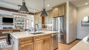 A modern kitchen with wooden cabinets, stainless steel appliances, and pendant lighting. - Granby Mtn Retreat w/ Ski Hill Views, Hot Tub (Granby)