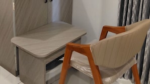 Un rincón de una habitación con un armario, una silla y una cortina.