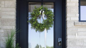 A black door with a white doormat, a potted plant, and a wreath. - Executive Luxury Condo  Corporate Stay  Sleeps 4 (Mount Forest)