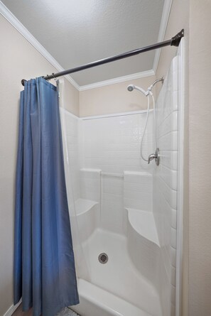 A shower with a curtain, a handheld showerhead, and a wall-mounted faucet. - Furnished Executive Suite Near DOW + Shintech - C2 (Plaquemine)