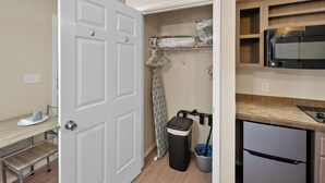 A compact kitchen with a refrigerator, microwave, and wooden cabinets.