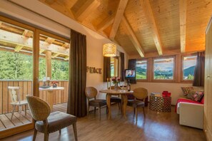 A wooden interior with a dining area, seating, and a television. - Chalet Mi Amur (Badia)