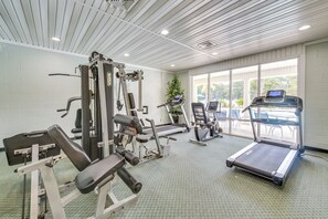 A gym with exercise equipment, a treadmill, and a large window with a view. - Gorgeous Ground Floor Condo Just Steps to Pool! (Calabash)