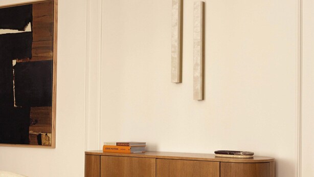 A modern living room with a wooden cabinet, a black sculpture, and a magazine on a coffee table. - Luxury Apt Climatise - 6p/3bdr - Arc de Triomphe (Paris)