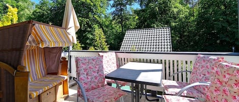 An outdoor patio with wicker furniture, a table, and chairs.