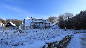 Et stort hus med mange vinduer og et sneklædt landskab.