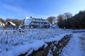 Ein großes Haus mit vielen Fenstern und einer verschneiten Landschaft.