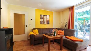 A living room with a sofa, a coffee table, and a fireplace. - Möwe Vacation Rental – Relaxation Between the Forest and the Baltic Sea - Küstenwaldhaus (Koserow)