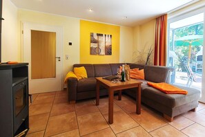 A living room with a sofa, a coffee table, and a fireplace. - Möwe Vacation Rental – Relaxation Between the Forest and the Baltic Sea - Küstenwaldhaus (Koserow)