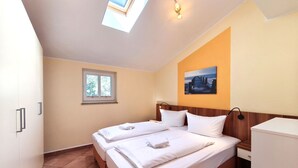 Hotelkamer met een bed, een raam, een schilderij aan de muur en een dakraam.
