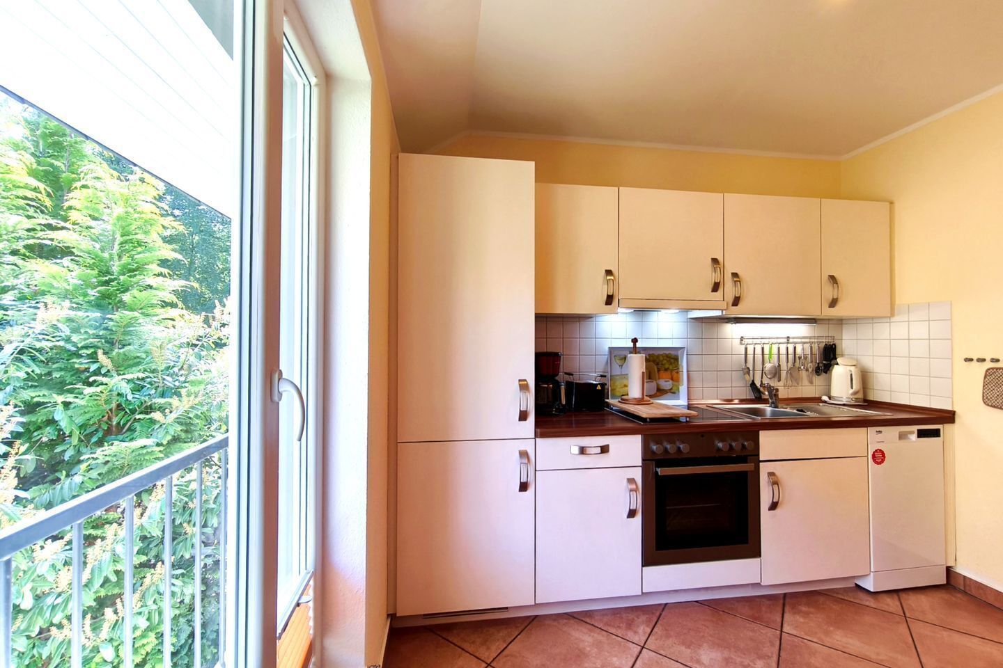 A modern kitchen with white cabinets, a stove, and a sink.