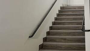 A staircase with wooden steps and a metal handrail. - 1 King Bed|Non-Smoking,Micfridge (Houston)