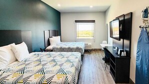 A hotel room with two beds, a desk, a television, and a window. - 2 Queen Beds|Non-Smoking,Kitchen (Houston)