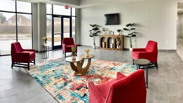 A spacious lobby with a large window, red chairs, a central coffee table, and a flat-screen TV mounted on the wall. - 2 Queen Beds|Non-Smoking,Kitchen (Houston)
