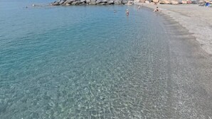 A beach with clear water, a rocky shoreline, and a few people. - Baia di Tempsa Beach and Sea (Amantea)