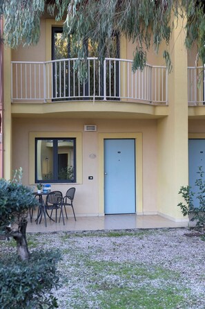 A two-story building with a balcony, a table with chairs, and a door. - Residence in Amantea with 2 bedrooms sleeps 6 (Amantea)