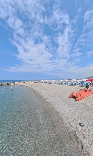 A beach with clear water, a pebble beach, and umbrellas. - Residence in Amantea with 2 bedrooms sleeps 6 (Amantea)