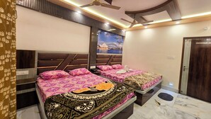 A hotel room with a bed, a ceiling fan, a wall mural, and a door.