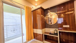 A bathroom with a glass door leading to a balcony, a wooden vanity with a mirror, and a marble floor.