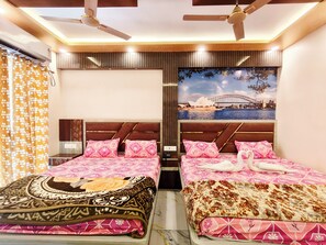 A double bed with patterned bedding, a ceiling fan, and a wall-mounted air conditioner.