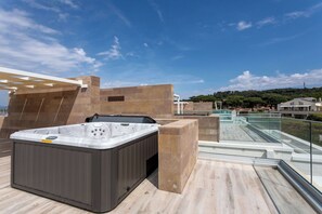 Ein Whirlpool auf einer Dachterrasse mit freiem Blick auf die umliegende Landschaft.