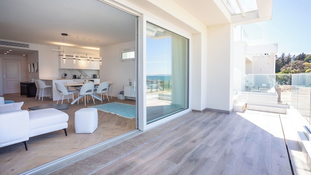 Ein modernes Interieur mit Essbereich, Küche und einer Glastür zum Balkon mit Blick.