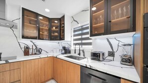 Een moderne keuken met houten kastjes, een ingebouwde magnetron en een vaatwasser.