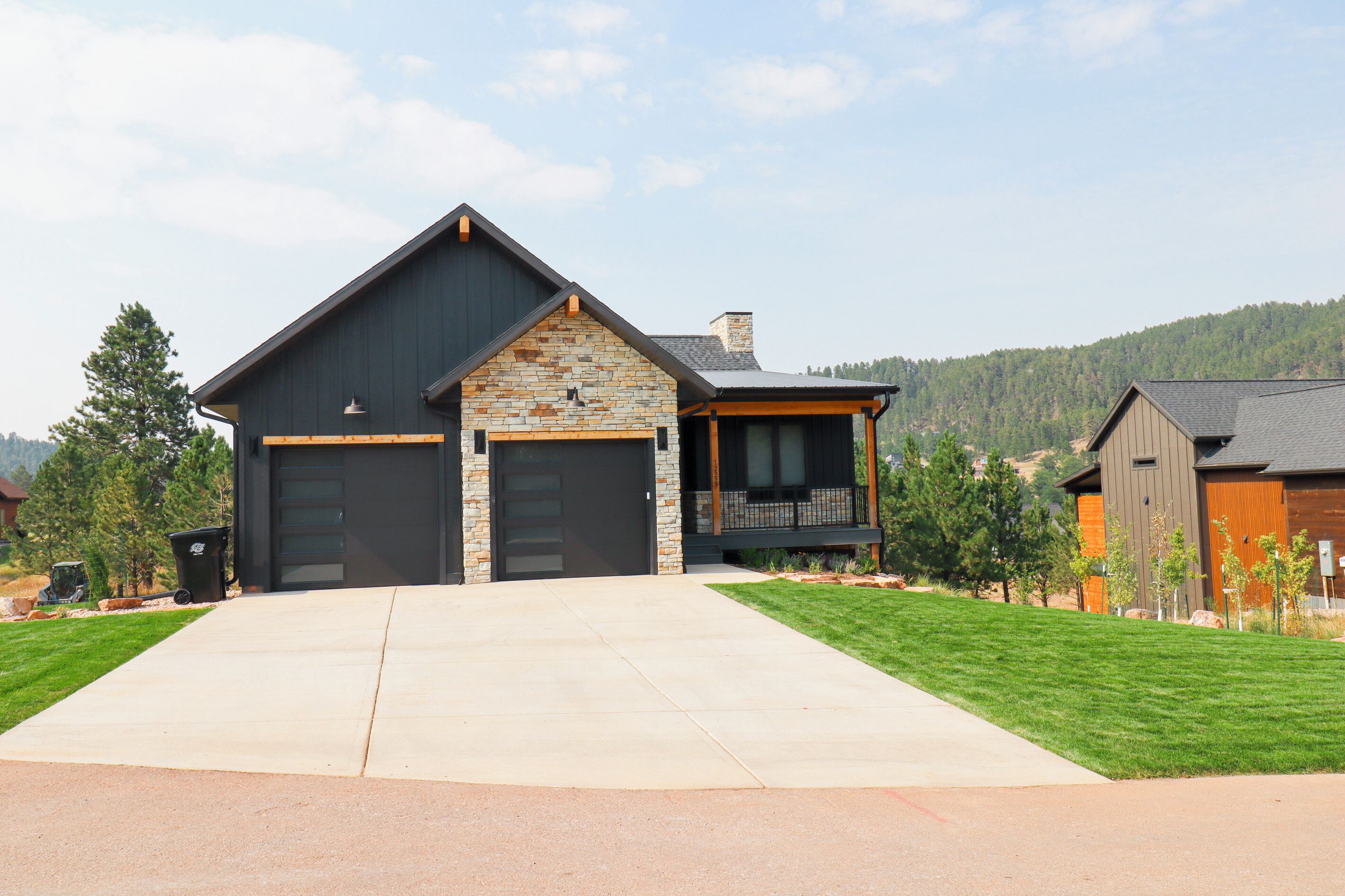 A modern two-story house with a stone facade and a large garage.