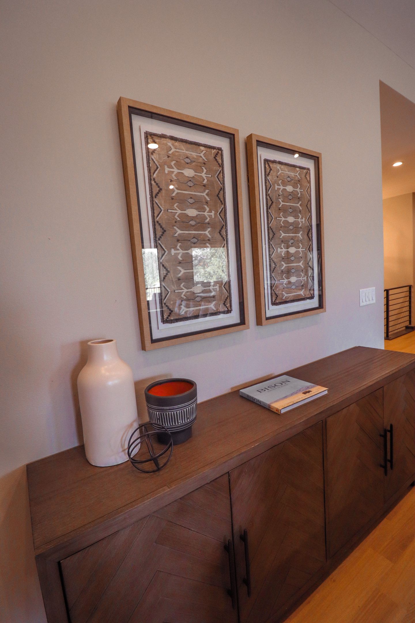 A wooden cabinet with a vase, a bowl, and a book on top.