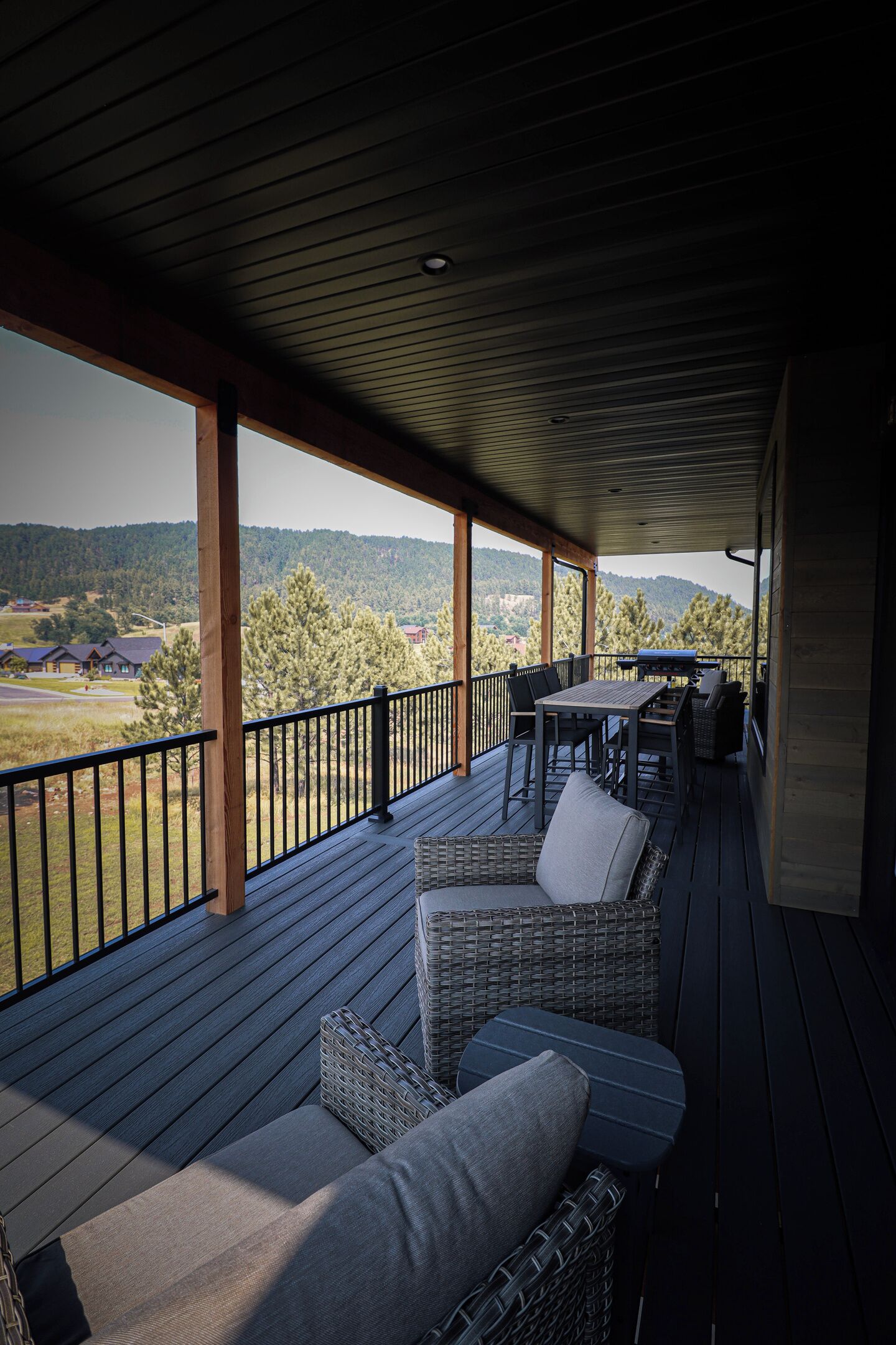 A covered outdoor area with a view of a forested landscape.