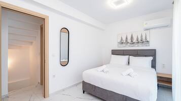 Un dormitorio con cama, espejo, cuadro y una lámpara en el techo.