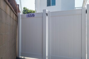 A white metal gate with a house number sign above it. - Chic 3-bedroom Modern Home Near SoFi Stadium & LAX, Comfortable with AC & WIFI (Inglewood)