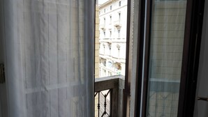 A view through a window with a balcony, featuring a building with classical architecture. - Piazza Duomo Exclusive Family Apartment (Milano)